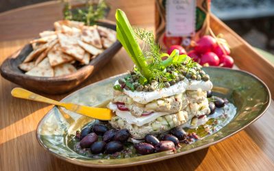 LAYERED HUMMUS WITH CAPERS, FRESH HERBS, AND GREEK OLIVES